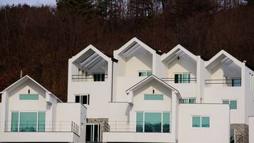 A multi-story building with a modern architectural design, featuring large windows and a flat roof.