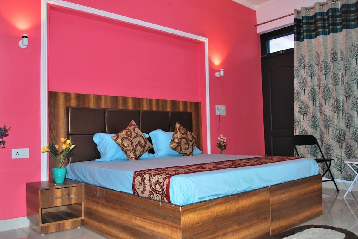 Une chambre à coucher avec un lit en bois, des murs roses et une fenêtre avec des rideaux.