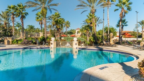 A pool area with palm trees, lounge chairs, and a clear blue pool. - Ffv8457ha - Regal Palms Resort & Spa - 4 Bed 3 Baths Townhouse (Davenport)