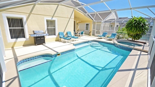 A covered outdoor swimming pool with lounge chairs and a grill. - Ffv8471ha - Highlands Reserve - 4 Bed 2 Baths Villa (Davenport)