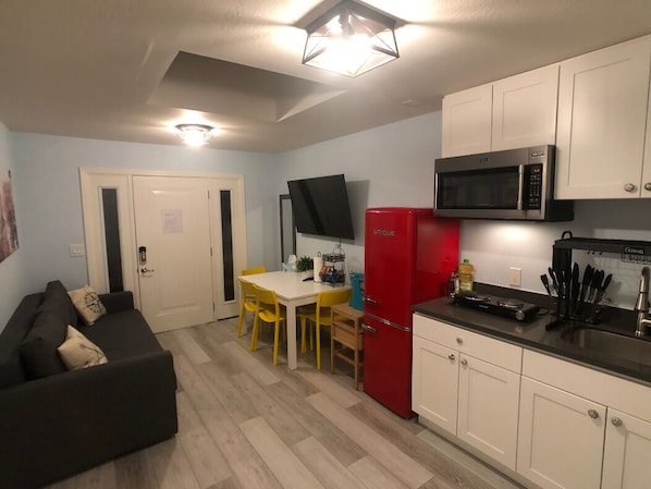 A compact living space with a kitchenette, a dining area, and a sofa.