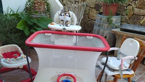 A baby play area with a baby walker, a high chair, and a rocking chair. - WONDERFUL CALALIBEROTTO (Sos Alinos)