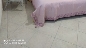 A bedroom with a bed, a chair, a bedside table, and a wall-mounted picture. - WONDERFUL CALALIBEROTTO (Sos Alinos)
