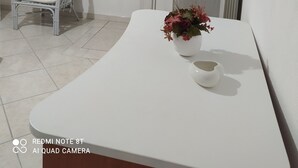 A minimalist room with a white vanity, a chair, a mirror, and a radiator. - WONDERFUL CALALIBEROTTO (Sos Alinos)