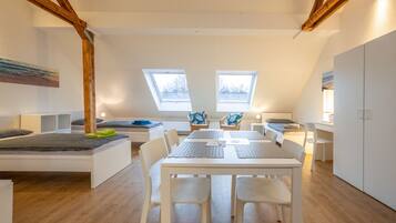 Une chambre de style loft moderne, dotée d’une grande verrière, d’un coin repas et d’une armoire intégrée.