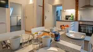 A dining area with a table set for breakfast, including plates, cups, and a jar of jam. - Meine Zeitwohnung (Essen)