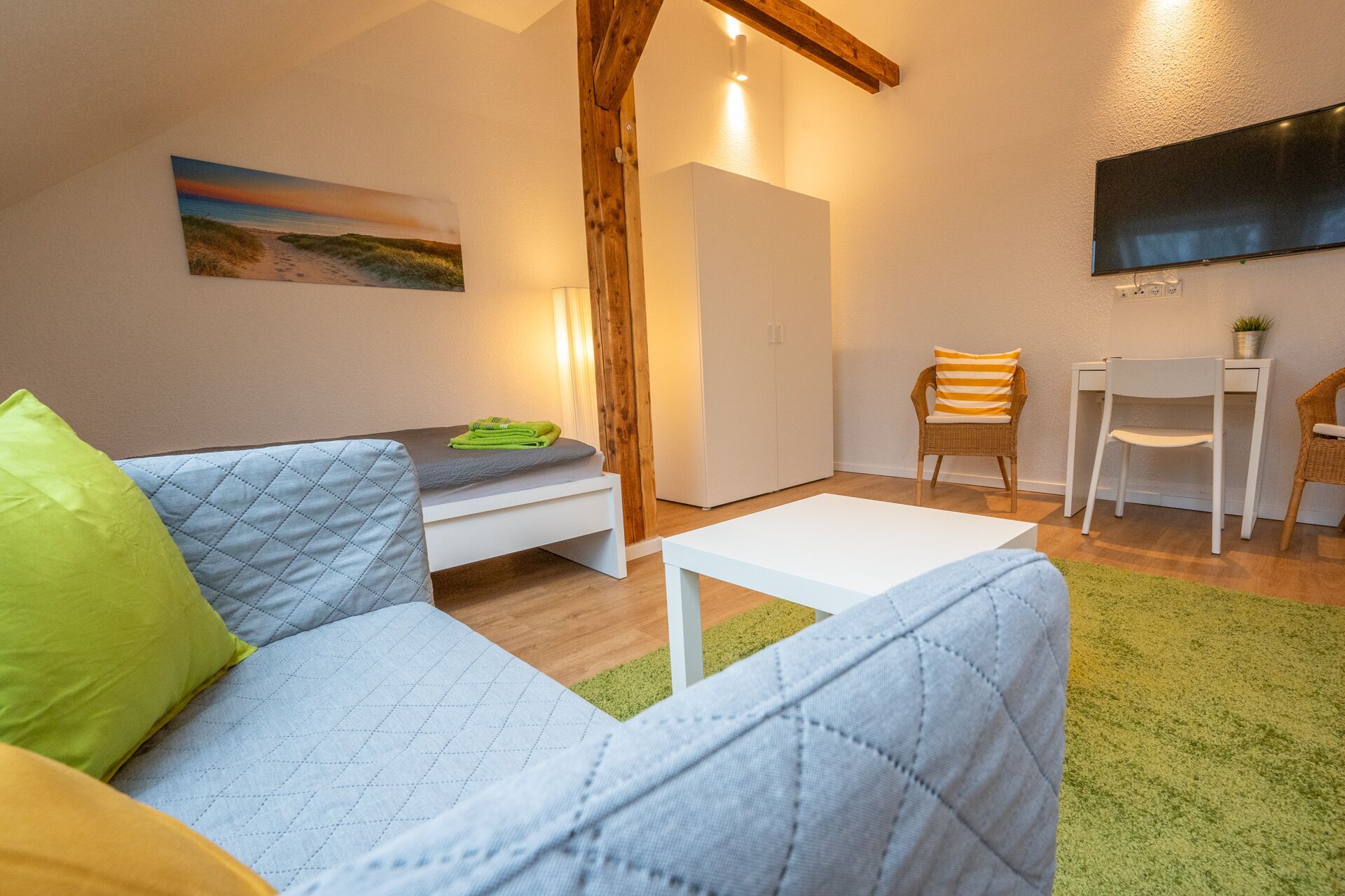 Una sala de estar acogedora con un sofá, una mesa de centro y un comedor con sillas y una mesita.
