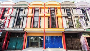 A multi-story building with a central entrance featuring a blue door and a signboard. - Hotel O Palem Mas Garden (Medan)