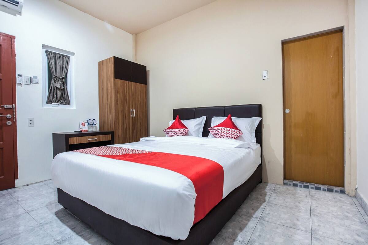 Ein ordentlich eingerichtetes Schlafzimmer mit einem Bett, einem Kleiderschrank und einem Nachttisch.