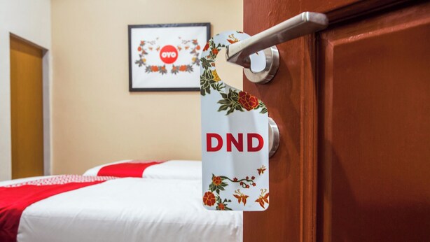A hotel room with a bed, a door with a handle, and a framed picture on the wall. - Hotel O Palem Mas Garden (Medan)