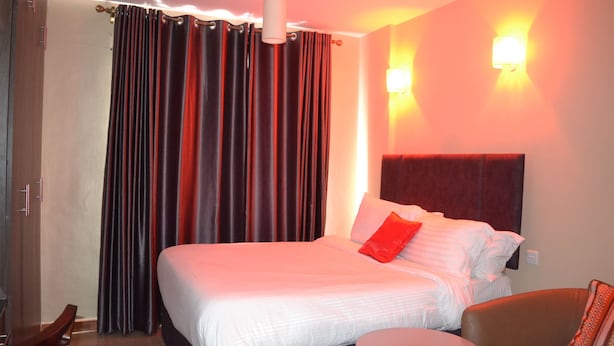 Ein Hotelzimmer mit einem großen Bett, einem runden Tisch und zwei Wandleuchten.