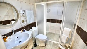 A bathroom with a sink, toilet, and shower area.