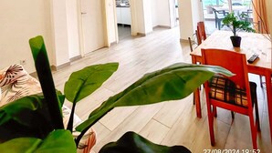 A spacious living area with a dining table, chairs, and a large window. - Family Choice with Pool View (Seixal)