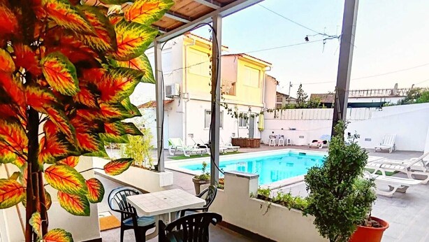 A covered patio with a pool, a dining area with chairs and a table, and potted plants. - Family Choice with Pool View (Seixal)