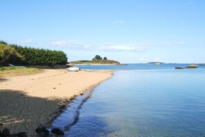 Ein Strand mit klarem Wasser, einem sandigen Ufer und einem kleinen Boot.