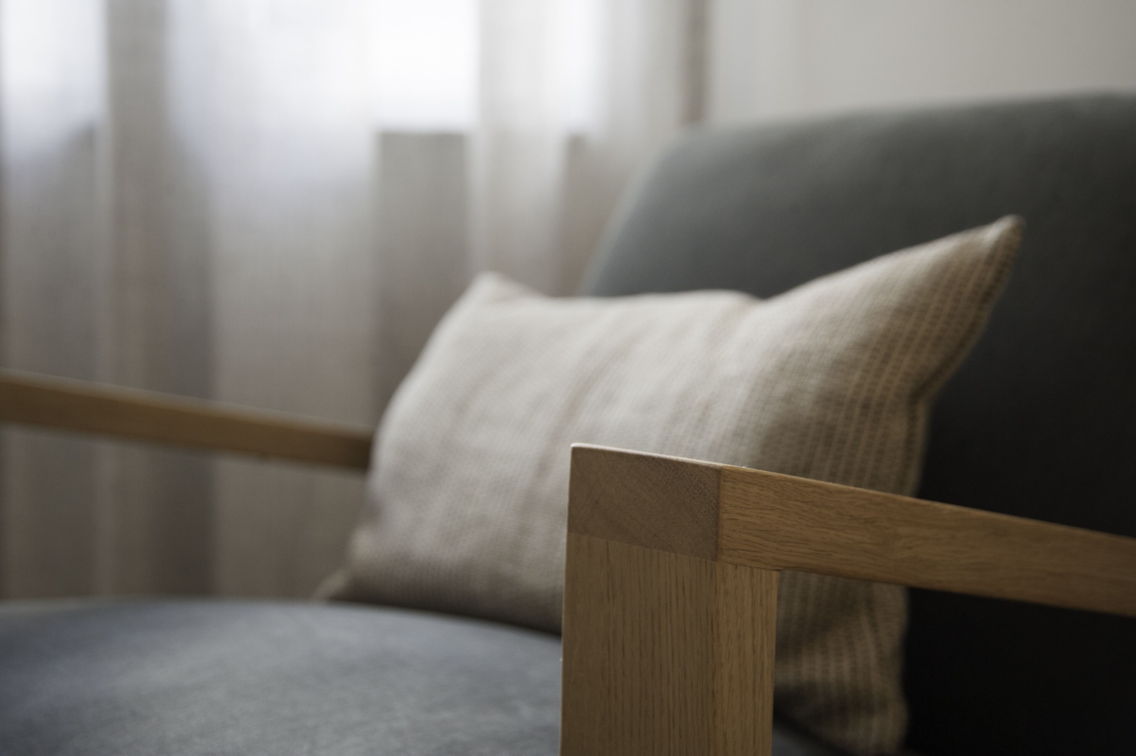A wooden chair with a grey cushion.