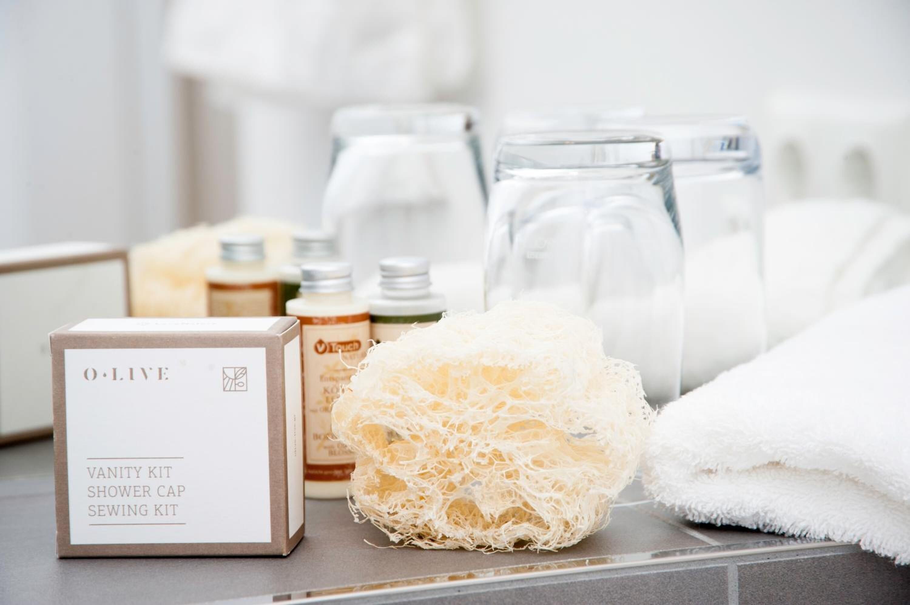 Kit da toilette con cuffia da doccia e kit da cucito, un asciugamano bianco e una spugna da bagno.