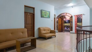 A living room with a sofa, a coffee table, and a wooden cabinet. - Hotel O Pantai Jaya (Pangandaran)