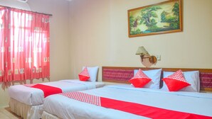 A hotel room with two beds, red and white bedding, a painting on the wall, and a window with red curtains. - Hotel O Pantai Jaya (Pangandaran)
