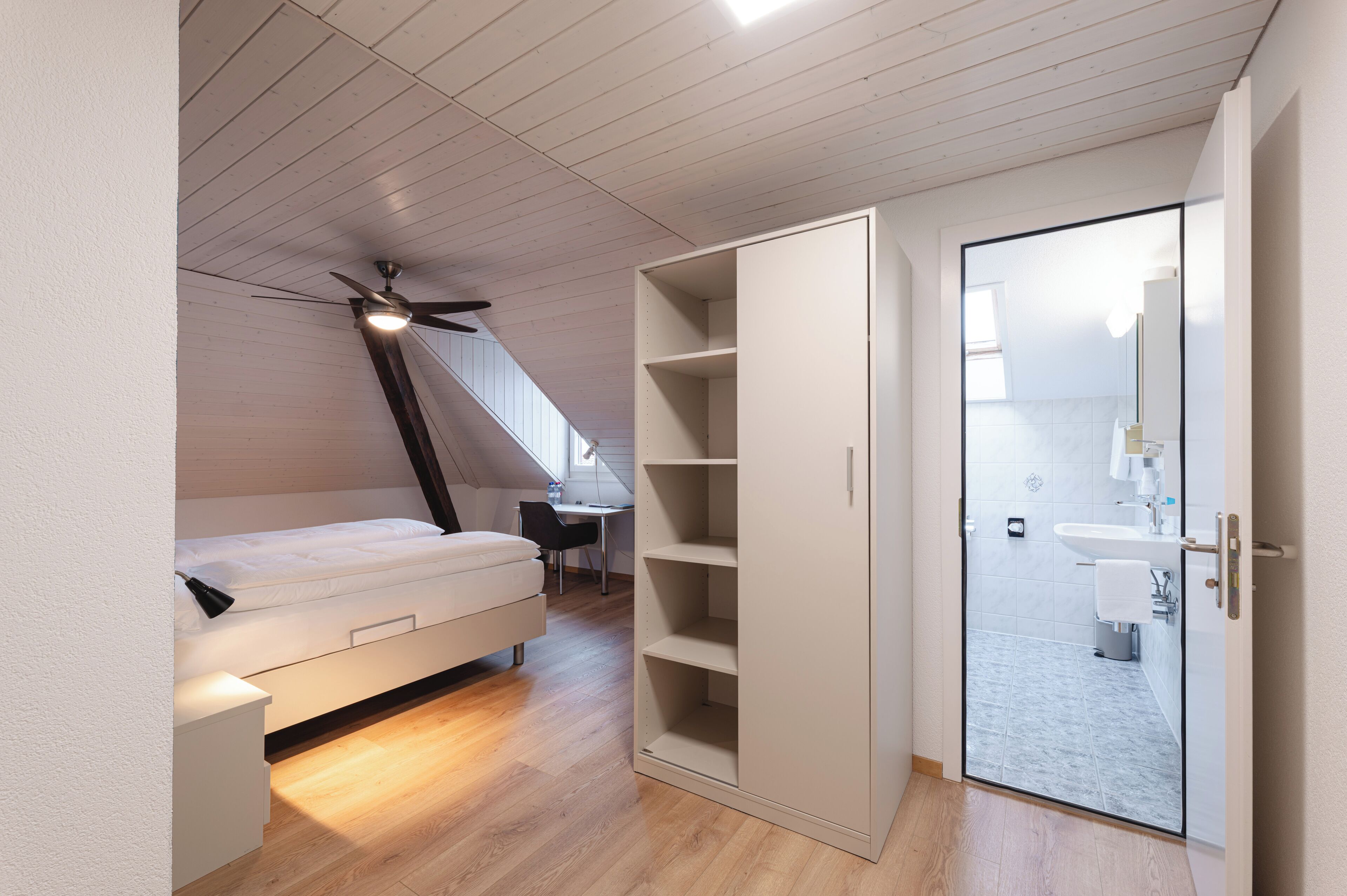 Ein Schlafzimmer mit Hochbett, Schreibtisch und begehbarem Kleiderschrank.