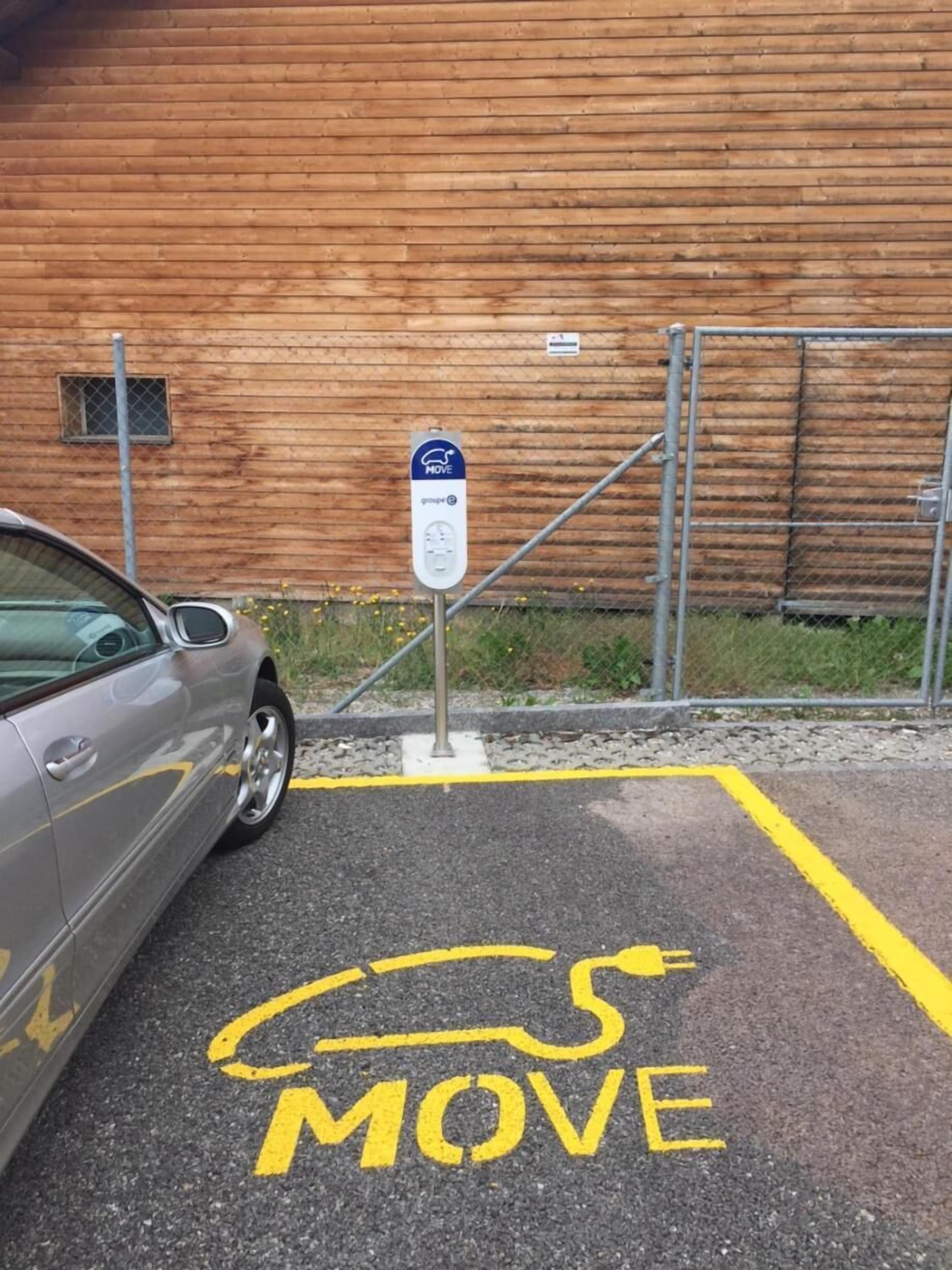 Un área de estacionamiento con un letrero que dice 'MOVE' y un automóvil estacionado al lado.