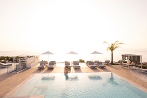 Een seizoensgebonden buitenzwembad en parasols bij het zwembad