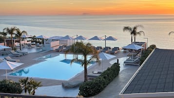 Una piscina al aire libre de temporada, sombrillas