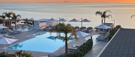 Piscine extérieure en saison, parasols, chaises longues