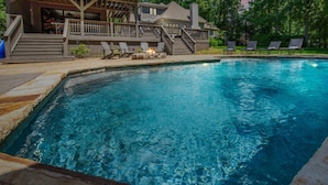 A swimming pool with lounge chairs and a deck area. - Nights on Normandy (Mooresville)