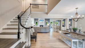 A spacious living area with a staircase, a dining area, and a kitchen. - Nights on Normandy (Mooresville)