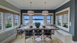 A dining area with a large table, four chairs, and two pendant lights. - Bridlewood Cove (Mooresville)