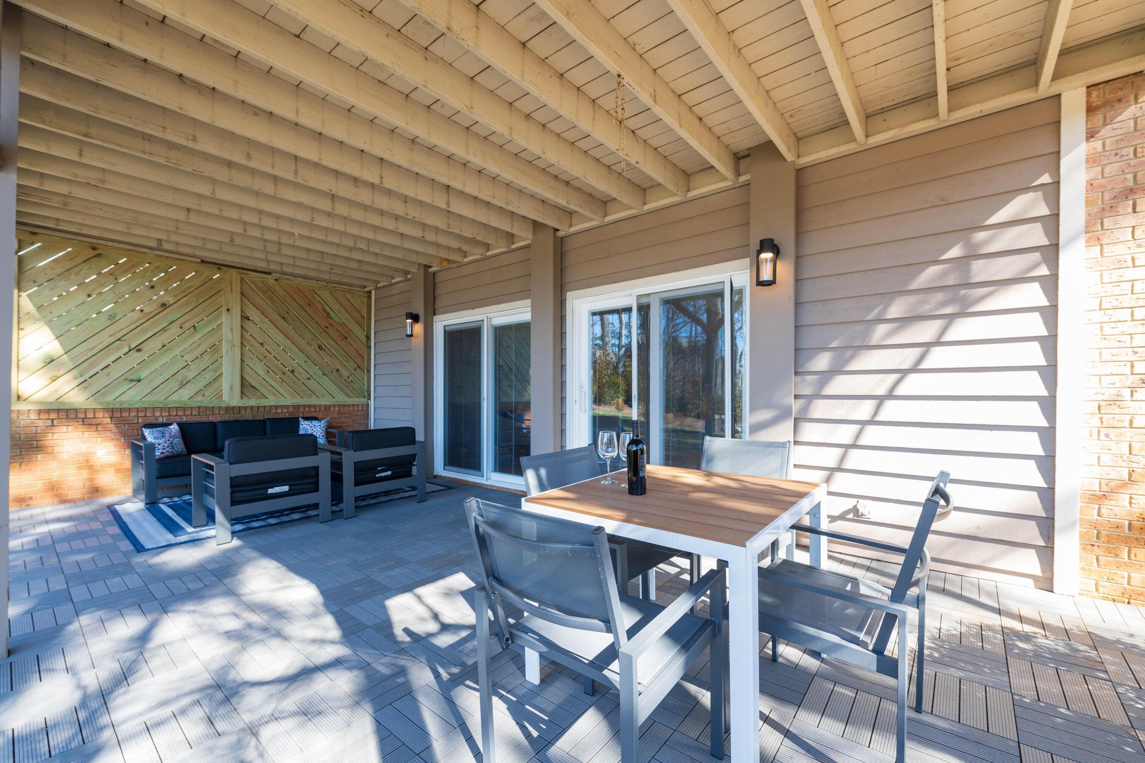 Une terrasse extérieure avec une table en bois, des chaises et un canapé.