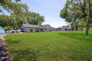 A residential property with a well-maintained lawn, a driveway, and a house with a grey roof and multiple windows. - Points End (Mooresville)