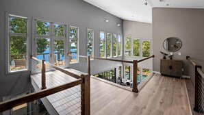 Un interior amplio con ventanas grandes, una terraza de madera y vistas al exterior.