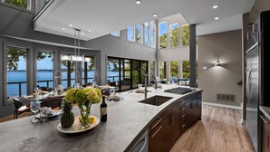 Una cocina moderna con una isla grande, un lavaplatos empotrado y vistas al mar.
