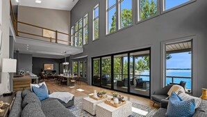 Un salón amplio con un sofá seccional gris grande, una mesa de centro y un comedor con mesa y sillas de madera.