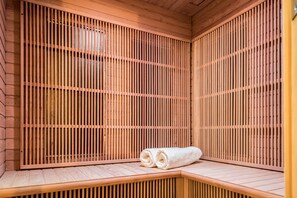 A wooden sauna with a bench and a rolled towel. - Hotel Föhrenhof (Naz Sciaves)