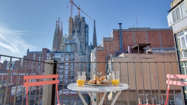 A table with breakfast items and drinks on a balcony with a view of a building under construction. - LUCASLAND (Barcelona)