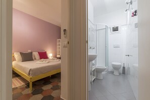 Guest room with a bed, sink, toilet, and shower area.