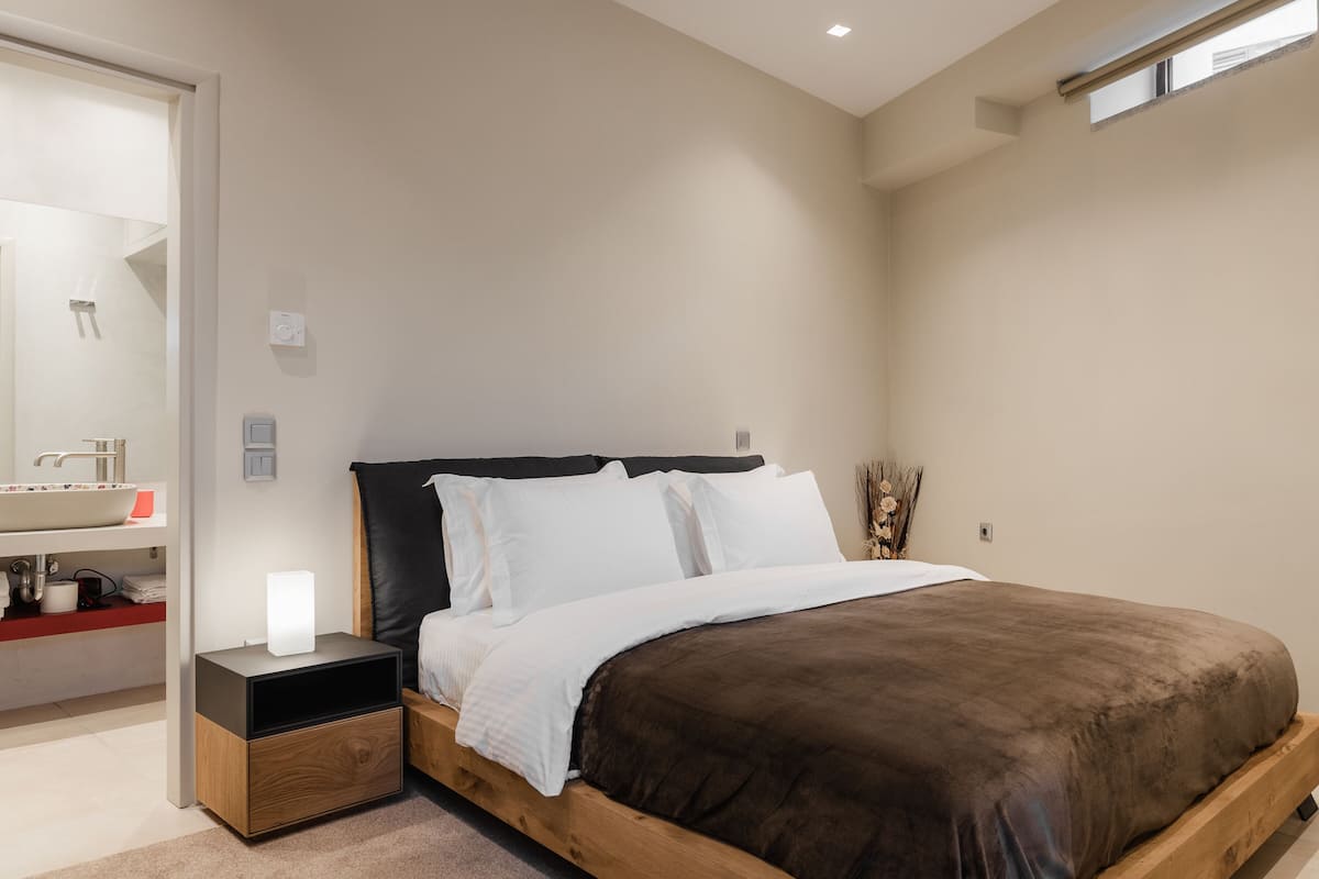 Une chambre à coucher avec un lit, une table de chevet et une commode.