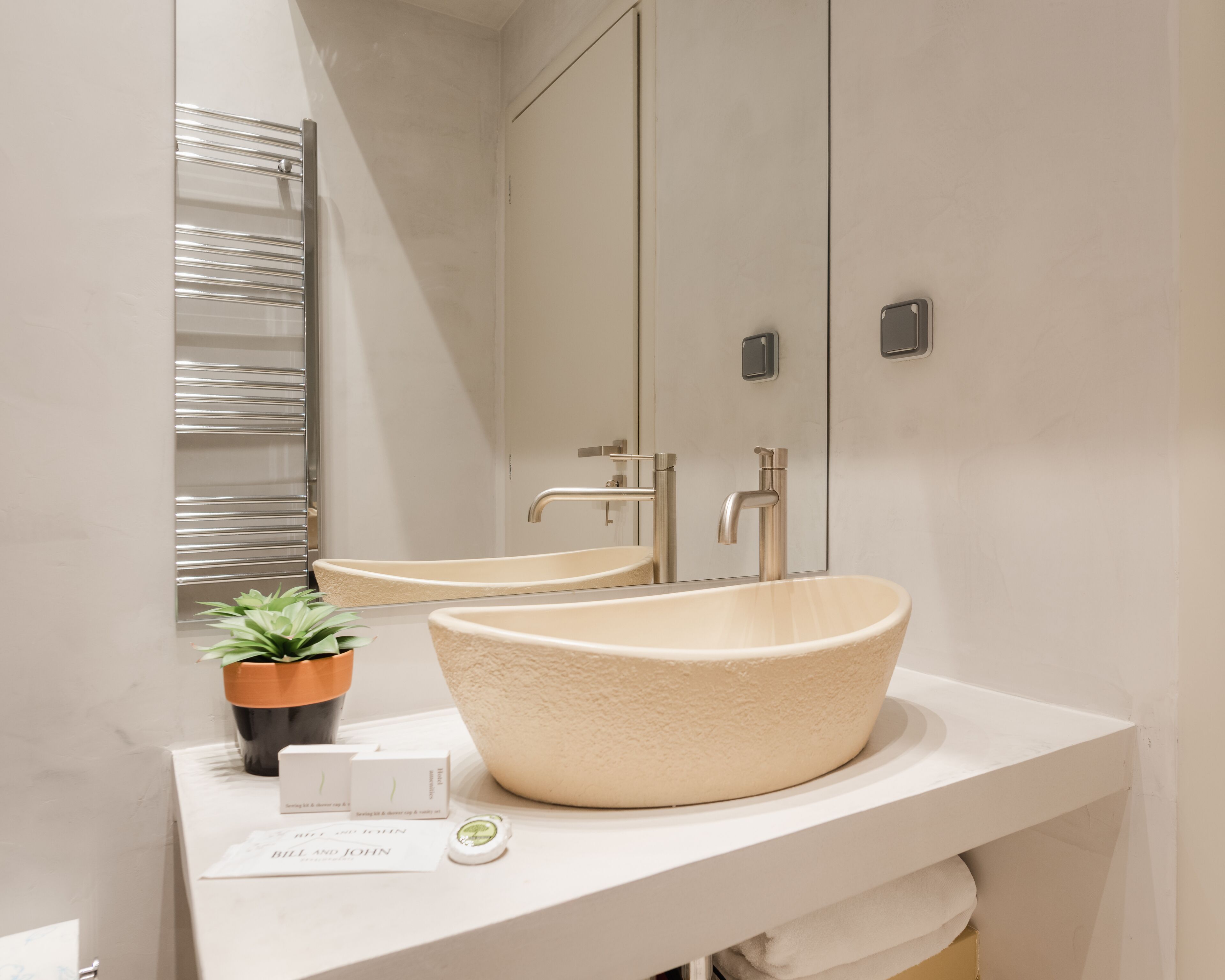 Un baño moderno con un lavabo grande y redondo, un espejo y un perchero para toallas.