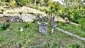 Ein Garten mit Steinelementen, Blumentöpfen und Statuen.