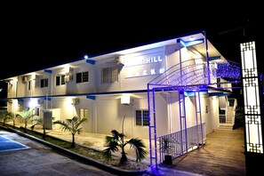 Vista frontal de la propiedad por la tarde o noche