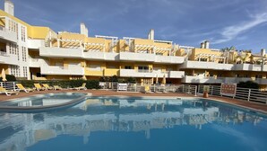 Una piscina con tumbonas y un cartel que indica las normas.