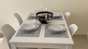 Une table à manger dressée avec des assiettes, des couverts et un saladier décoratif.