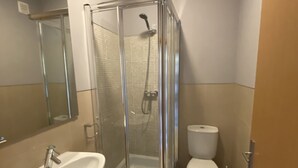 Une salle de bain moderne avec une douche à parois de verre, un lavabo et des toilettes.