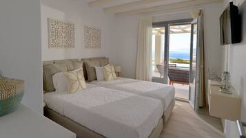 A hotel room with two beds, a balcony with a pool view, and a TV mounted on the wall.