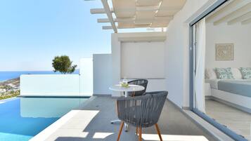 Eine moderne Außenpatio mit Pool, Tisch mit Stühlen und einer Couch mit Kissen.