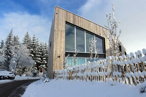 Un edificio moderno con amplios ventanales y fachada de madera.