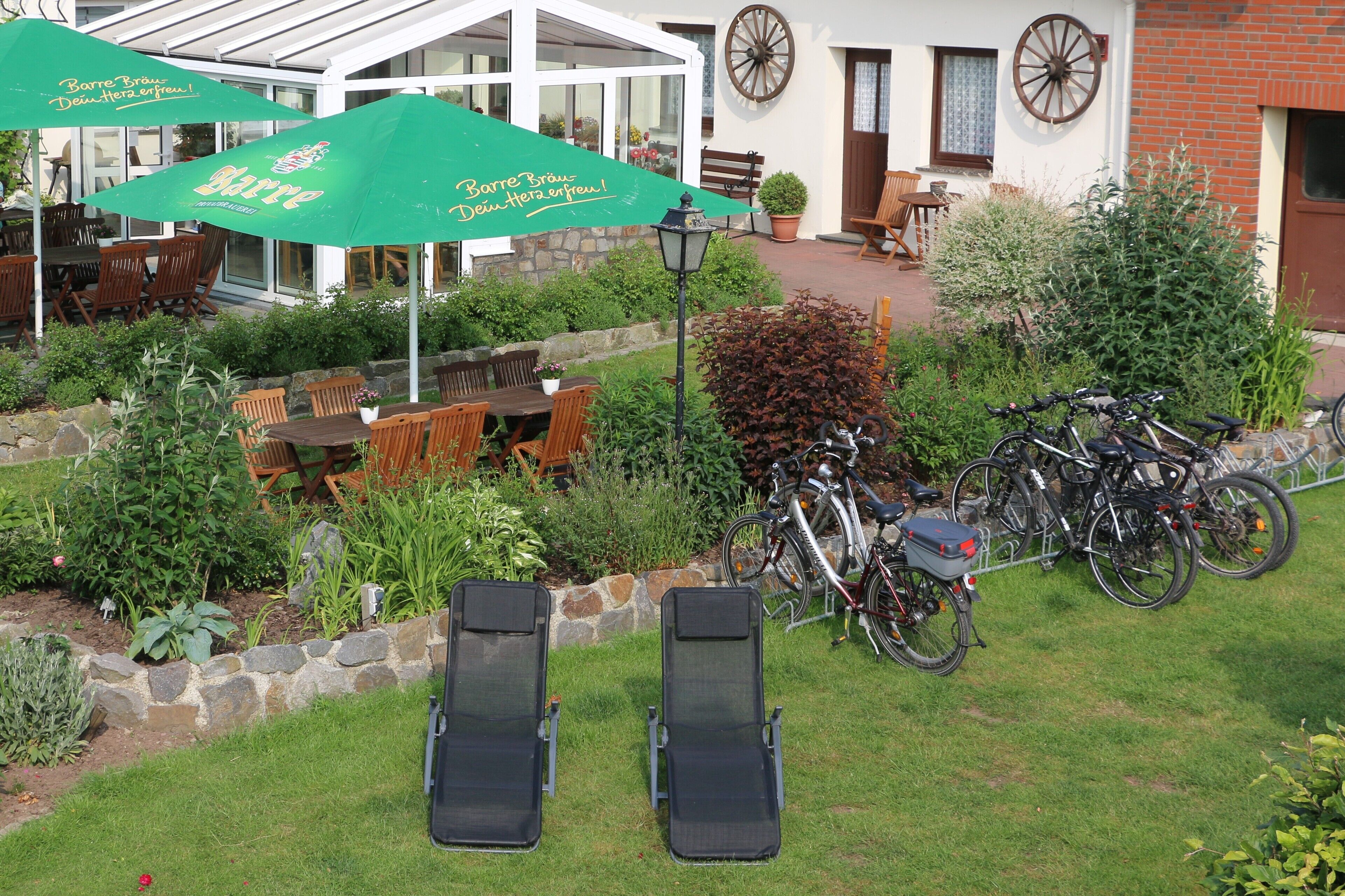 A patio area with outdoor seating, bicycles, and a stone wall.